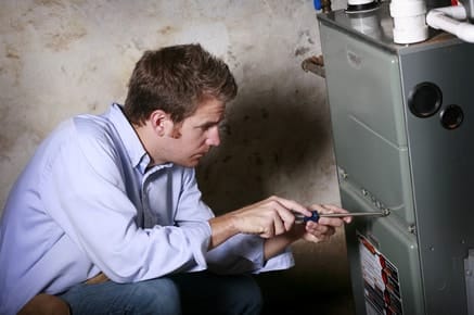Trusted HVAC Professionals - Technician performing an inspection on a heating & air conditioning system