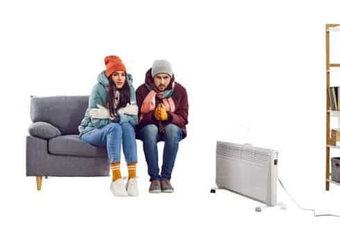Couple wearing Jackets and trying to stay warm inside their home